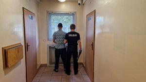 Policjant stoi z zatrzymanym mężczyzną.