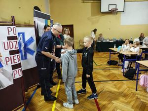 Nadkomisarz Rafał Adamek I Zastępca Komendanta Powiatowego Policji w Pabianicach gratuluje laureatom konkursu.