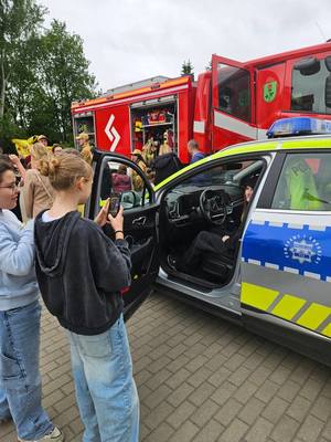 Dzieci fotografujące radiowóz.