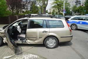Miejsce zdarzenia na którym widać rozbite auto i stojący obok radiowóz.