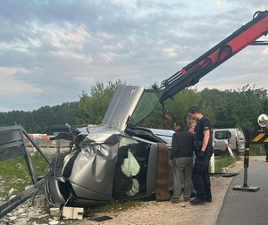Auto biorące udział w zdarzeniu. Przy pojeździe stoi policjant i mężczyzna wykonujący jego holowanie.