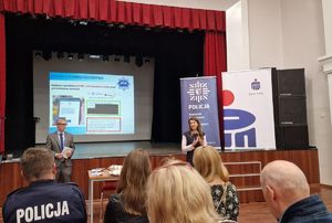 Pracownicy banku omawiają tematykę oszustw na spotkaniu z mieszkańcami Lutomierska.