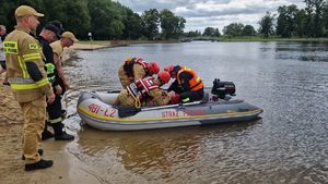 Strażacy na łódce wyciągają na brzeg tonącą osobę.