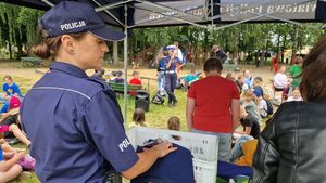 Policjantka omawia przed uczestnikami wydarzenia zasady bezpieczeństwa w ruchu drogowym.