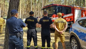 Policjant i strażacy w miejscu obozowiska.