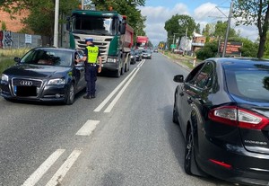 Policjant bada kierującego samochodem alkomatem.