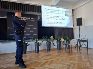 Policjant omawiający prezentację multimedialną.