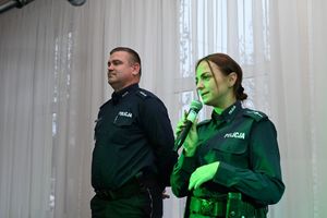 Policjantka mówi do mikrofonu, obok niej stoi policjant.