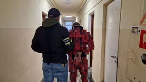 Nieumundurowany policjant stoi z zatrzymanym mężczyzną.