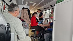 Wnętrze krwiobusa i osoby rejestrujące się do oddania krwi.