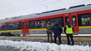 Policjant, funkcjonariusz Służby Ochrony Kolei i żołnierz stoją na dworcu przed pociągiem.