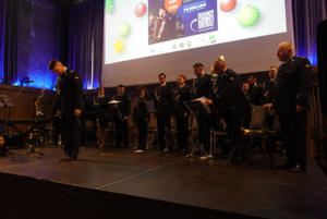 Policyjni muzycy stojący na scenie.