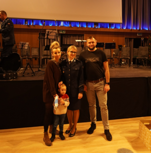 Policjantka stoi z kobietą, mężczyzną i małym chłopcem.