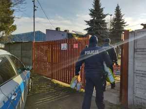 Policjanci wchodzą z karmą do schroniska.