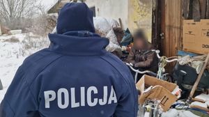 Policjantka, za nią siedzi mężczyzna będący w kryzysie bezdomności.