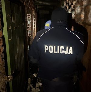 Policjant ze strażnikiem miejskim sprawdzają pustostan.