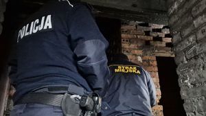 Policjant i strażnik miejski sprawdzają pustostan.