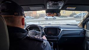 Policjant siedzi wewnątrz radiowozu.