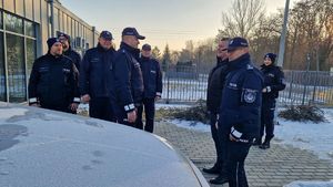 Policjanci i burmistrz stoją na tle nowego radiowozu.