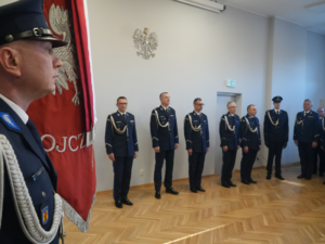 Zgromadzeni komendanci na tle pocztu sztandarowego.