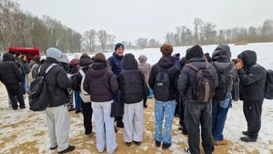 Policjant stoi wraz ze zgromadzoną młodzieżą.