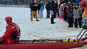 Strażak siedzący na desce. W tle uczestnicy pokazu.