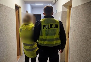 Policjant stoi z zatrzymaną kobietą.