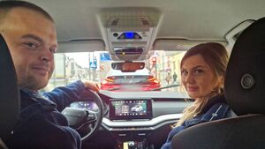 Policjant i policjantka siedzą wewnątrz radiowozu.