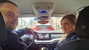 Policjant i policjantka siedzą wewnątrz radiowozu.