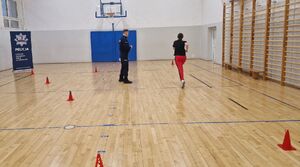 Kobieta podczas biegu. Czynność nadzorują umundurowani policjanci.