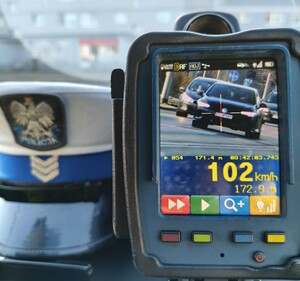 Ręczny miernik prędkości, na którym widać samochód jadący z prędkością 102 km/h.