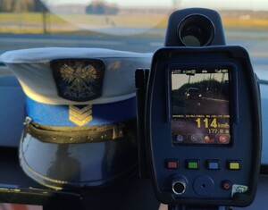 Ręczny miernik prędkości, na którym widać samochód jadący z prędkością 114 km/h.