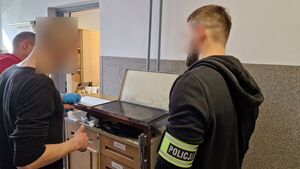 Policjanci podczas pobierania odcisków palców podejrzanego.