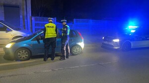 Umundurowani policjanci kontrolują pojazd.