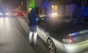 Nieumundurowany policjant kontroluje pojazd.