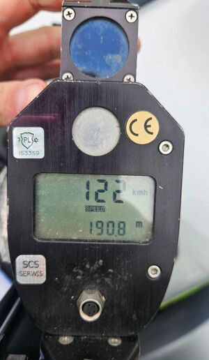 Ręczny miernik prędkości z wynikiem 122 kilometrów na godzinę.