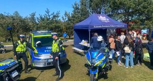 Stanowisko profilaktyczne, na którym widać policjantów, radiowóz i motocykle oraz granatowy namiot, pod którym są uczestnicy wydarzenia.