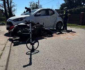Policjant wykonujący oględziny uszkodzonych pojazdów.