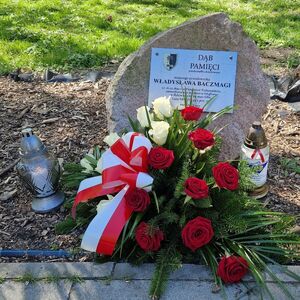 Pomnik przy którym umieszczono kwiaty i znicze.