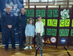 Policjant i policjantka z laureatami konkursu.