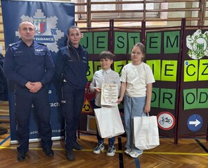 Policjant i policjantka z laureatami konkursu.