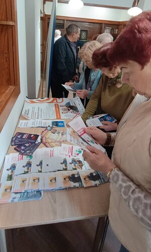 Seniorzy przeglądający materiały informacyjne.