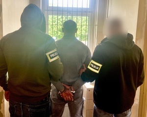 dwóch policjantów z zatrzymanym mężczyzną