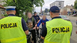 Policjanci kontrolują dwóch rowerzystów.