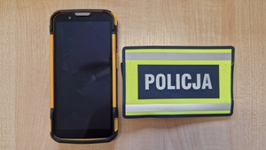 Skradzione urządzenie, obok opaska z napisem Policja.