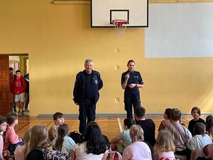 Funkcjonariusze prowadzący prelekcję w sali pełnej dzieci