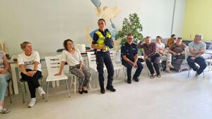 Policjantka pokazuje sprzęt wykorzystywany w codziennej służbie uczestnikom spotkania.