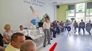 Kierowniczka Warsztatu Terapii Zajęciowej trzyma w ręku policyjną pałkę.