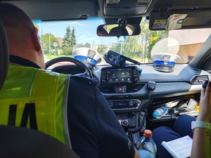 umundurowany policjant siedzący w radiowozie