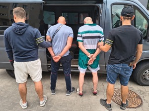 funkcjonariusze wydziały kryminalnego trzymają zatrzymanych